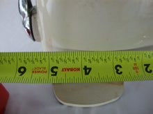 Load image into Gallery viewer, MCM retro Ice O Mat hand crank ice crusher with cream and red metal and plastic body with chrome flip top lid and handle. Crusher has wear/tear, finish loss, scratches, stains and measures about 8" height by 5" width by 4" depth.
