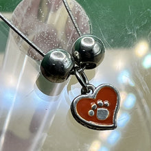 Load image into Gallery viewer, Necklace with Pendant, Sterling Silver, Orange Enamel with Pawprint, Two Flanking Beads
